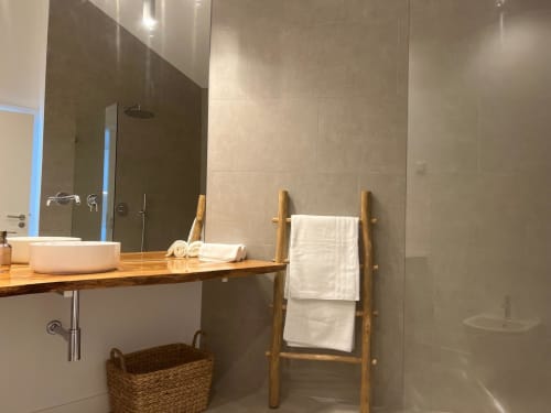 Banheiro moderno da villa Casa Ingrina com escada para toalhas em madeira, pia tipo vessel e chuveiro aberto em Bordeira, Portugal