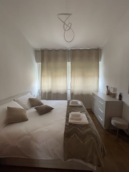 Bright bedroom at Varenna by Foot with double bed, white linens, beige curtains, and modern furnishings in Varenna