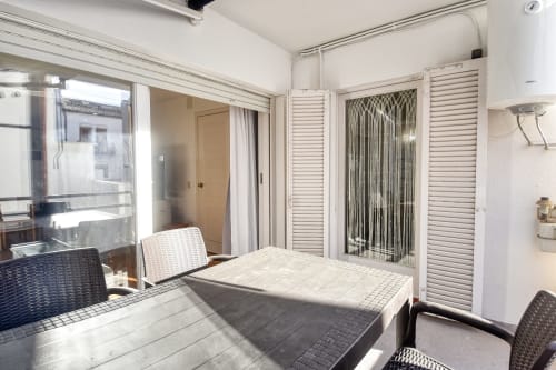 Bright apartment dining area in Calella, Palafrugell with outdoor furniture, glass doors, and natural sunlight