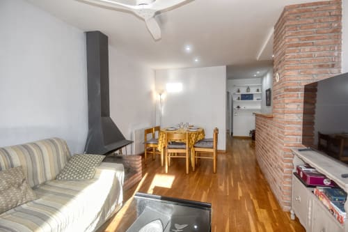 Modern apartment in Calella with fireplace, dining area, wood flooring, and brick chimney in Palafrugell