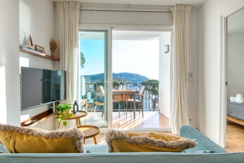 Modern apartment living room with sea views in Palafrugell, balcony furniture and coastal landscape