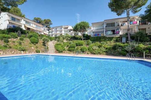 Sparkling shared pool at Finques Garcia Enrich apartment complex in Palafrugell with Mediterranean gardens and sea view