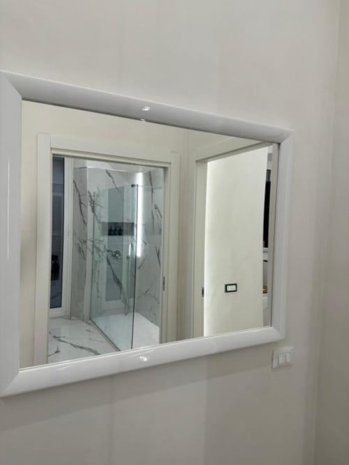 Specchio moderno nel bagno dell'appartamento Enjoy House Bracciano con riflesso della doccia in marmo