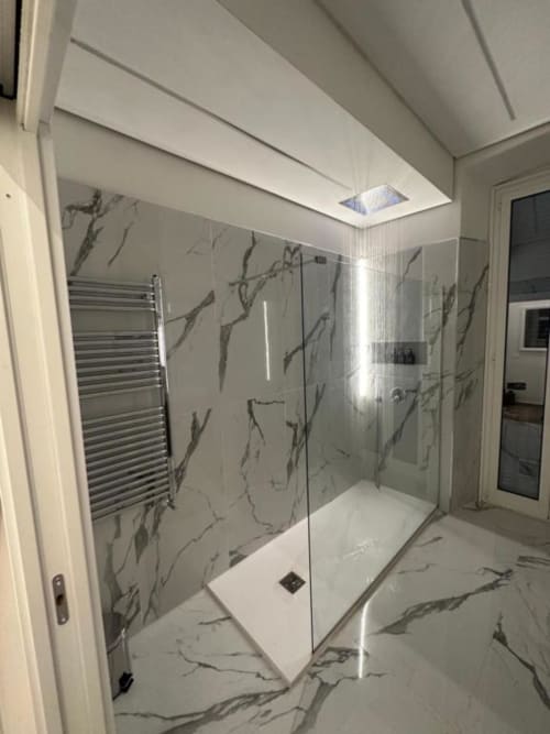 Bagno moderno con piastrelle effetto marmo, doccia con box in vetro e scaldasalviette nell'appartamento Enjoy House Bracciano
