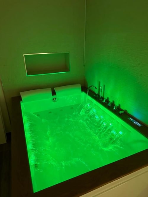 Vasca da bagno moderna con illuminazione LED verde neon nell'appartamento Enjoy House Bracciano, Bracciano Italia