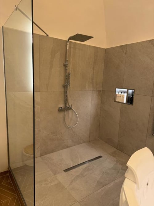 Moderno bagno con doccia aperta, soffione pioggia e box in vetro nell'apartamento Enjoy House Bracciano