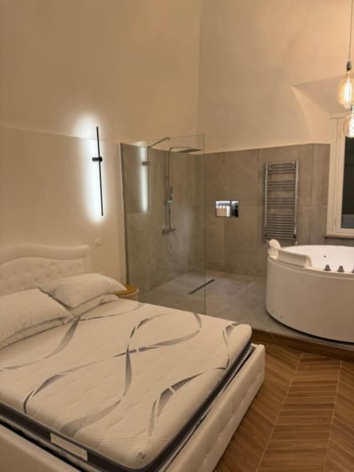 Camera moderna presso Enjoy House Bracciano con letto, bagno en-suite, vasca angolare e doccia con soffione a pioggia
