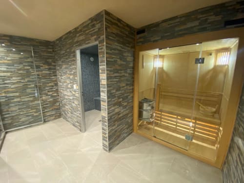 Espace spa luxueux au gîte Le Domaine du Bez avec sauna et douche à l'italienne aux carrelages multicolores