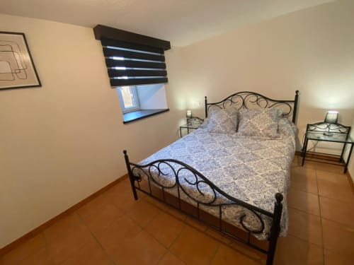 Chambre cosy du gîte Le Domaine du Bez à Saint Laurent d'Olt avec lit en métal et vue sur les montagnes