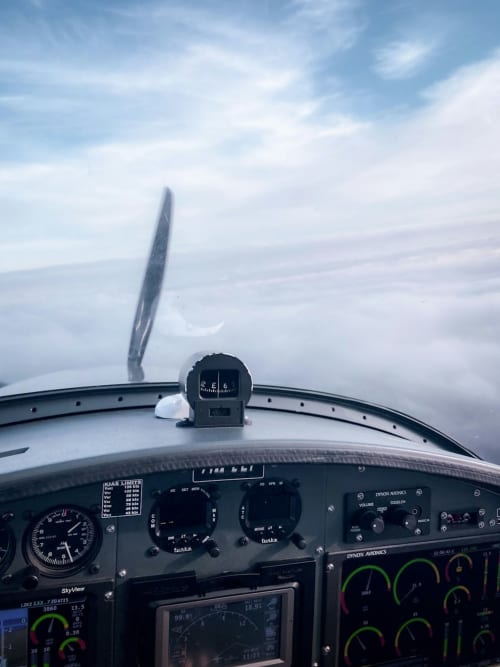 Vista dalla cabina di pilotaggio in volo sopra Bracciano, Italia con bussola e strumenti visibili