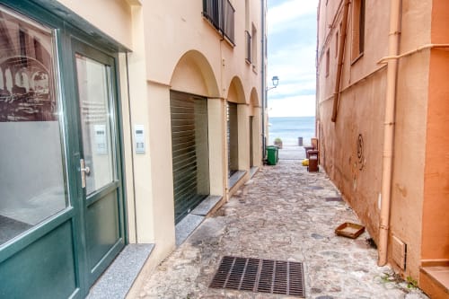Charming beachfront alley in Palafrugell with colorful apartment facades and sea views at Finques Garcia Enrich