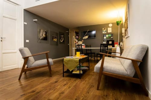Salotto moderno del B&B C'era una Volta a Palermo con poltrone anni '50, pareti scure e pavimento in legno.