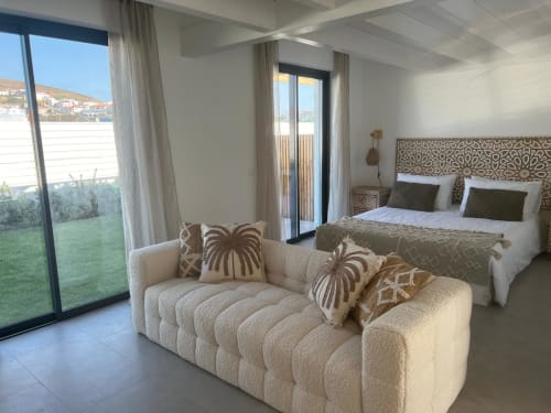 Quarto de villa moderna em Casa Zavial, Bordeira com vista para o mar, sofá creme, cabeceira estampada, acesso ao jardim