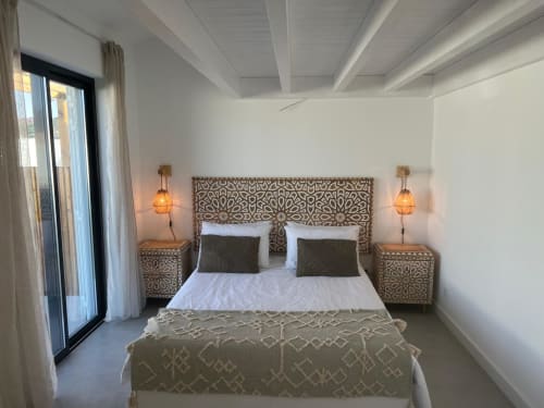 Bright modern bedroom at Casa Zavial villa in Bordeira with patterned headboard, white linens, pendant lamps, and sea view