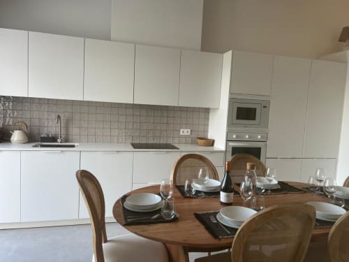 Cozinha e área de refeições modernas na villa Casa Barranco com armários brancos, mesa de madeira posta e aço inoxidável