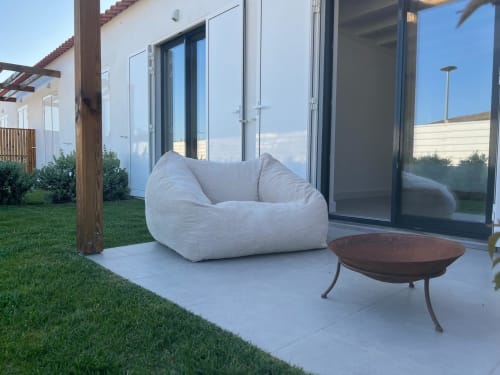 Poltronas de exterior brancas na varanda da Villa Casa Barranco em Bordeira com vista para o mar e portas de vidro modernas