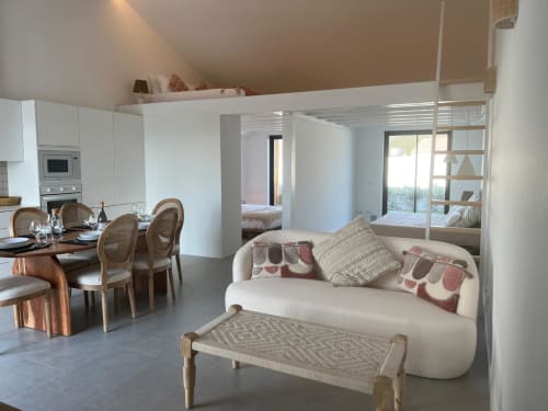 Sala de estar moderna com sofá curvo creme, área de refeições e cozinha em Bordeira, Portugal Casa Barranco