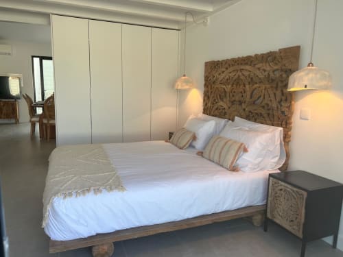 Quarto espaçoso da villa Casa Barranco com cabeceira de madeira entalhada, roupa de cama branca, luminárias pendentes e closet moderno