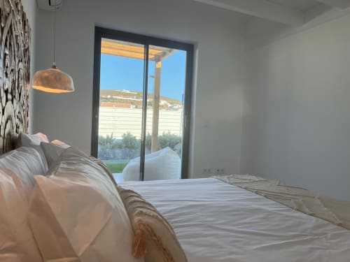 Quarto luminoso com vista para o mar na villa Casa Barranco em Bordeira, Portugal, com móveis modernos e portas de vidro