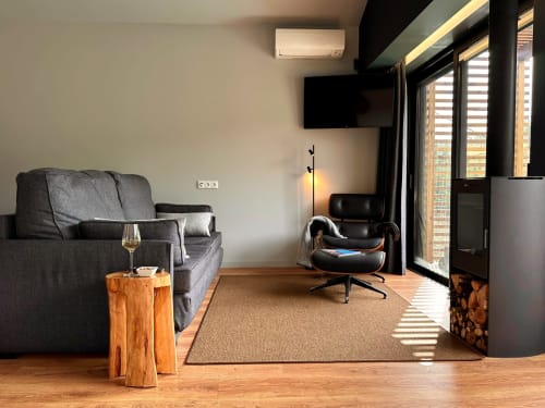 Moderna sala de estar da villa Em Xisto na serra de Góis, com sofá cinzento, televisão de ecrã plano e vistas para a montanha