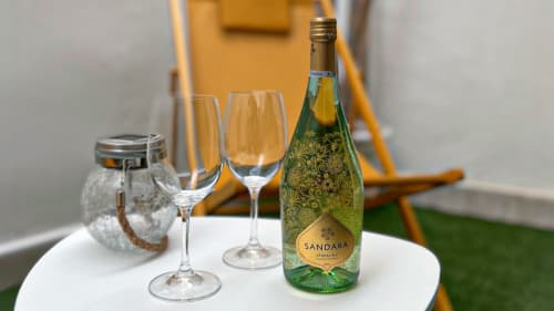 Botella de espumante Sandara con copas de champagne sobre la mesa en Casa Torrens Mar y Montaña, Polop de la Marina