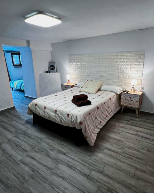 Dormitorio moderno en Casa Torrens Mar y Montaña en Polop de la Marina con cama queen, cabecero texturizado, piso de madera y