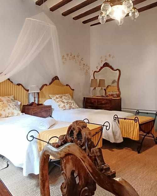 Santiago room at Casa Peregrinando B&B in Navarrete with wooden beds, yellow striped headboards, and city views