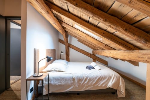 Chambre cosy sous les toits avec poutres en bois apparent, literie blanche et vue sur les montagnes au chalet Domaine de l'Epigny