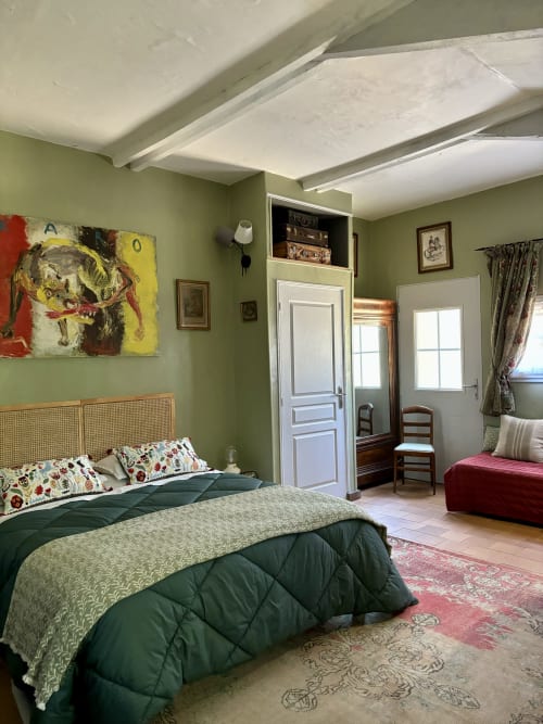 Chambre Fleur bedroom at Domaine Du Commandeur B&B in Mondragon with green walls, rattan headboard, and garden view balcony