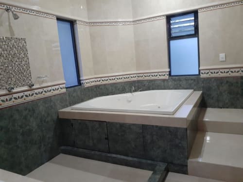 Baño moderno del Hotel El Candelero en Yuriria con bañera empotrada, detalles en azulejos verdes y espejo grande