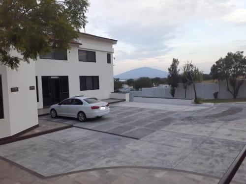 Moderno hotel blanco con estacionamiento y vista a las montañas en Yuriria, México