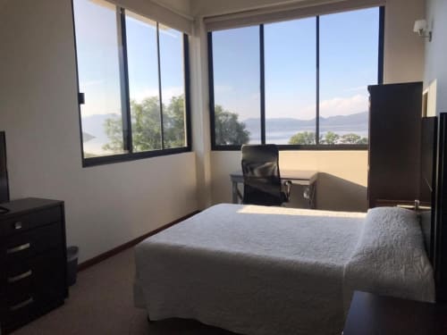 Habitación moderna del Hotel El Candelero en Yuriria con vistas panorámicas al lago desde ventanales de piso a techo