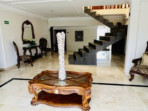 Elegante vestíbulo del Hotel El Candelero en Yuriria con pisos de mármol, mobiliario de madera ornamentado y gran escalera
