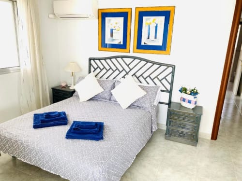 Modern beach view bedroom at Tads Holiday Lets Benidorm with geometric patterned bed, blue accents, and framed artwork