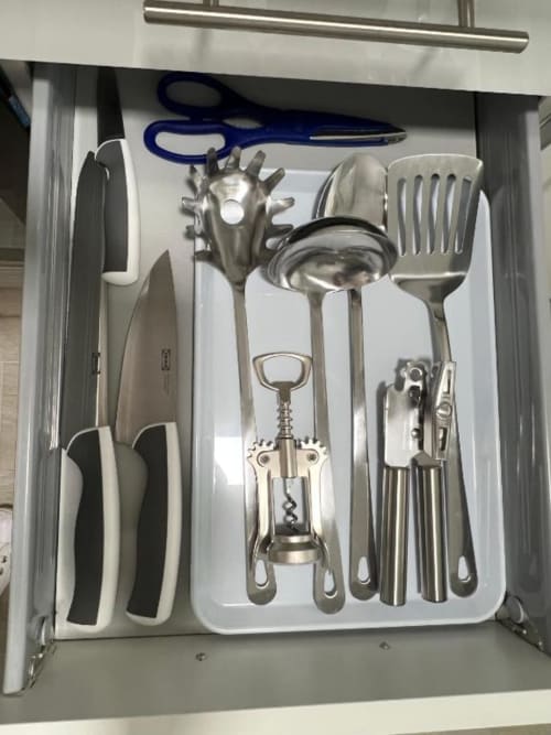 Organized kitchen utensil drawer in Lidersol Apartments Benidorm, displaying knives, ladle, corkscrew, and cooking tools