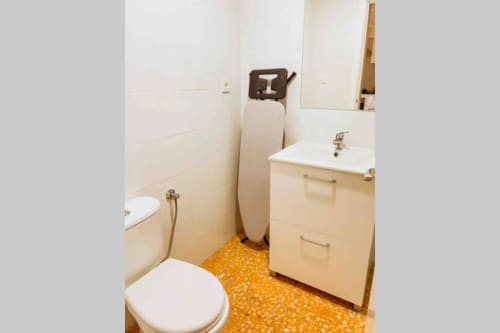 Bathroom in Mariscal Apartments, Benidorm with toilet, sink vanity, water heater, and orange tile flooring