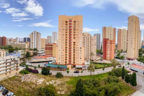 Mariscal Apartments in Benidorm with colorful residential towers, pool view, and cityscape skyline under blue sky