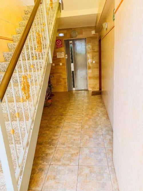 Building hallway with tiled flooring, staircase, and elevator at Zafiro Apartments, Benidorm
