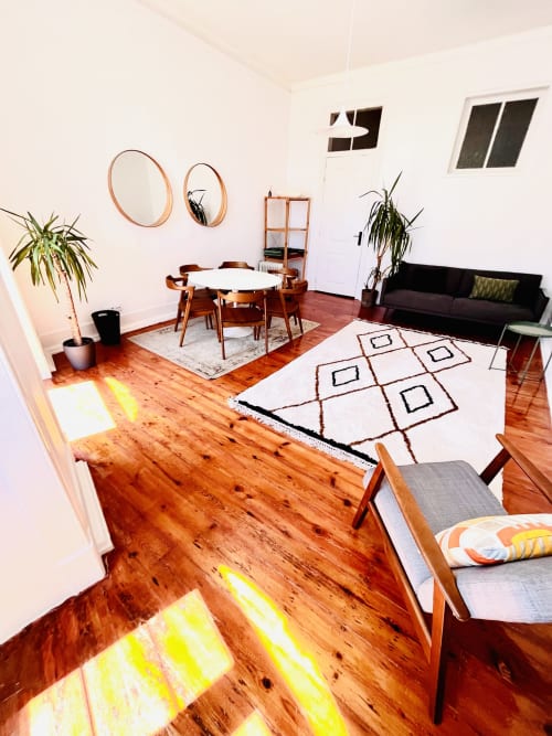 Modern living room at Royal Prince Garden Apartments in Lisboa with wooden floors, dining area, and black sofa