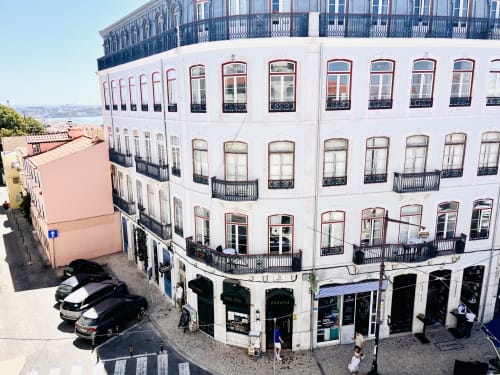 Royal Prince Garden Apartments in Lisboa, a white corner building with elegant balconies and ground-floor shops, viewed from