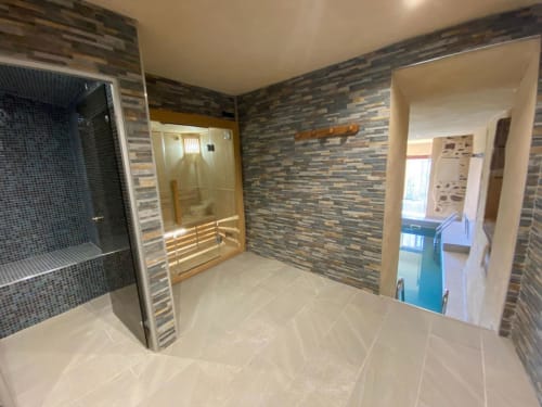 Espace spa moderne à la villa Le Domaine du Bez avec sauna, douche et carrelage à rayures