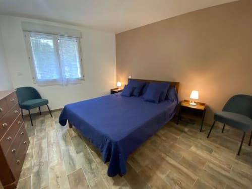 Chambre spacieuse à la villa Le Domaine du Bez à Saint Laurent d'Olt avec lit bleu, vue sur les montagnes et éclairage chaleureux