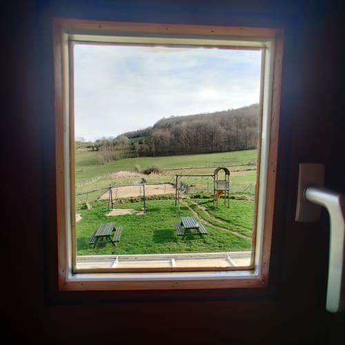 Tuinuitzicht van appartement La Ferme De Werpin in Hotton met picknicktafels, speelstructuren en landelijk platteland