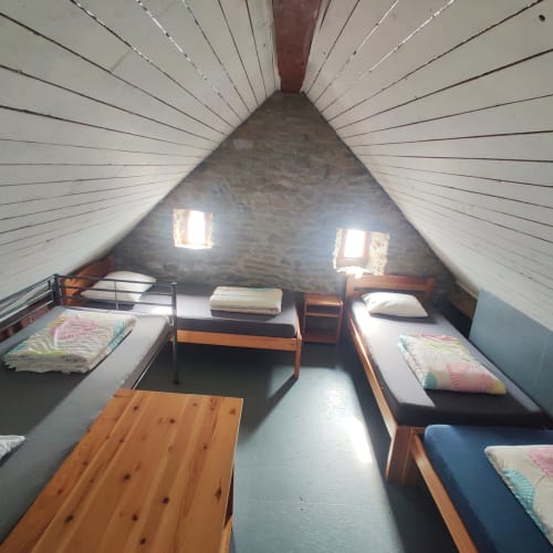 Gezellig zolderslaapkamer in La Ferme De Werpin met schuine plafonds, houten bedden en natuurlijk licht van twee ramen