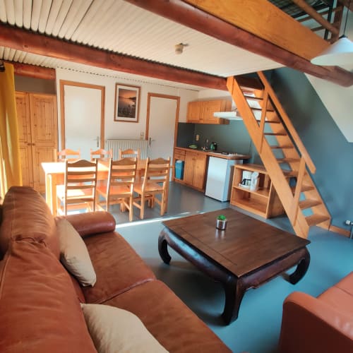 Ruim appartement in La Ferme De Werpin met woonkamer, eetkamer, keuken, houten trap en tuinuitzicht