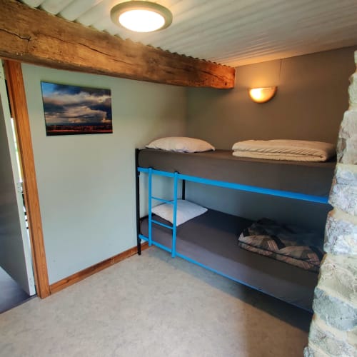 Cozy bunk bed room at La Ferme De Werpin apartment in Hotton with wooden beams and warm lighting