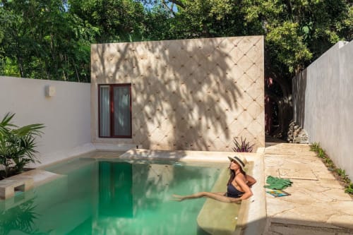 Mujer en la piscina de la Casa Tuch, Mérida, con arquitectura moderna y vistas al jardín tropical