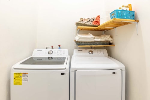 Lavandería de la Casa Tuch cottage con lavadora y secadora Samsung, estantes de madera con toallas y cestas de almacenamiento, Mérida