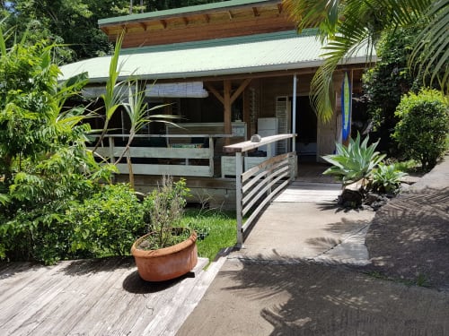 Tropical bungalow cottage at Le Bougainvillier Blanc in Pointe Noire with wooden deck, sea view, and lush garden
