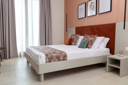 Modern Queen Room at Altavilla Boutique Holidays in Marsala with terracotta accent wall and sea view balcony